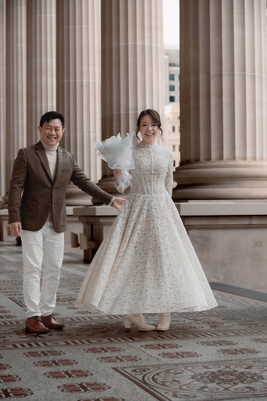 A bride twirling in front of her smiling partner at Parliament House, Melbourne